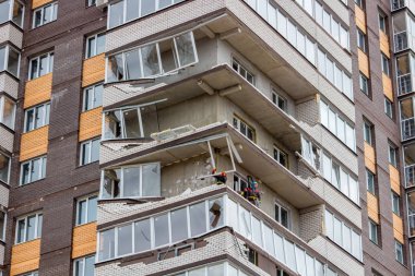 OBNINSK, Rusya - 22 Nisan 2018: Hasar sonucu olarak bir güçlü kasırga rüzgar 20 katlı ev loggias. İşçilerin zarar görmüş yapıları ortadan kaldırmak.