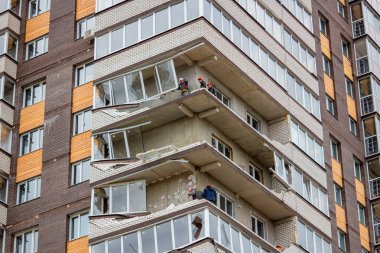 OBNINSK, Rusya - 22 Nisan 2018: Hasar sonucu olarak bir güçlü kasırga rüzgar 20 katlı ev loggias. İşçilerin zarar görmüş yapıları ortadan kaldırmak.