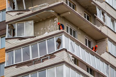 OBNINSK, Rusya - 22 Nisan 2018: Hasar sonucu olarak bir güçlü kasırga rüzgar 20 katlı ev loggias. İşçilerin zarar görmüş yapıları ortadan kaldırmak.