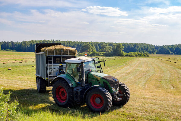 Kaluga region, Russia - June 2018: Harvesting of bales with agricultural equipment