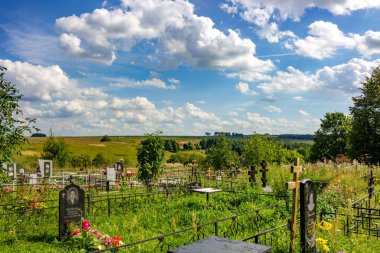 Maryino, Russia - August 2018: Russian Orthodox cemetery in the village of Maryino (former Zapazhye), Zhukovsky District, Kaluzhskiy Region, Russia. A beautiful view of the fields and the blue sky clipart