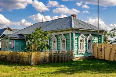 Timashovo, Russia - August 2018: Old village log house with beautiful carved platbands. Zhukovsky district, Kaluzhskiy region clipart