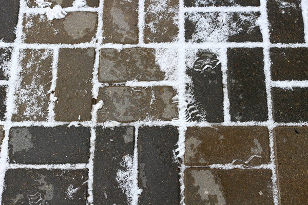 Sidewalk tiles in winter with trace