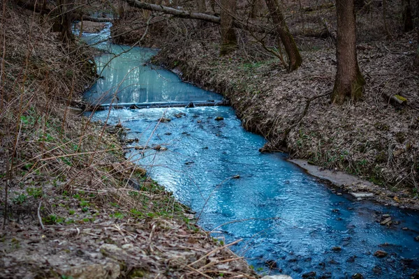 Painted in a bright blue river after illegal discharge of polluting liquid