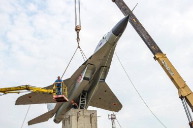 OBNINSK, RUSSIA - JUNE 28, 2016: Installation of the MiG-29 monument on the pedestal  clipart
