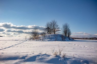 Barrow bir Ortodoks ile çapraz karla kaplı tarlanın ortasında. Kutepovo Köyü, ZHUKOVSKIY bölgesi, Kaluzhskiy bölgesi