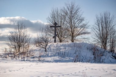 Barrow bir Ortodoks ile çapraz karla kaplı tarlanın ortasında. Kutepovo Köyü, ZHUKOVSKIY bölgesi, Kaluzhskiy bölgesi
