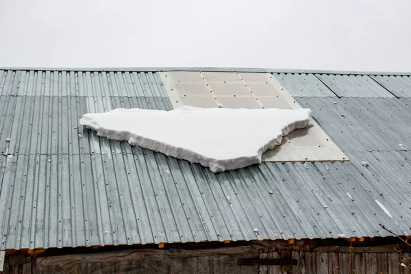 A layer of snow in the spring on the roof
