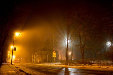 Bir gece sis sırasında dağınık ışık ile uyuyan bir alanı