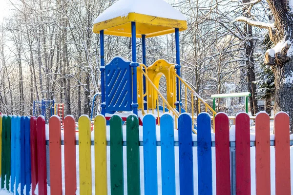 Playground and multicolored fence near the house