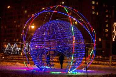 OBNINSK, RUSSIA - DECEMBER 2018: Street art object in the form of a glowing ball on a city street, beautiful decoration on the theme of the atom