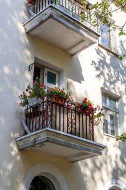 Çiçekli tencere çok öykülü bir cephe üzerinde küçük bir balkon görünümü oluşturma