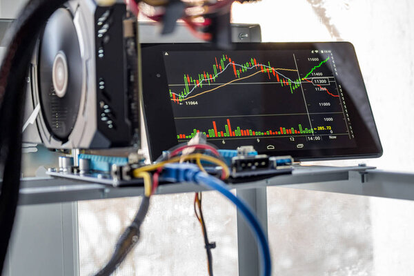 Home mining farm for mining cryptocurrency. Plot currency exchange rate on the tablet