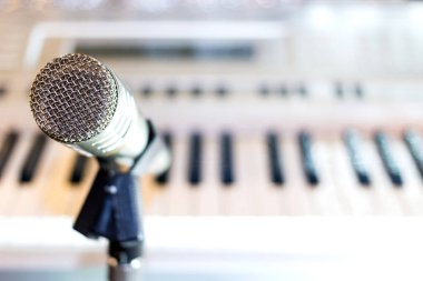 Raf yakın çekim üzerinde gümüş mikrofon. Klavye synthesizer içinde belgili tanımlık geçmiş