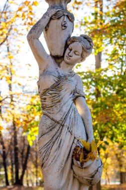 OBNINSK, Rusya - Ekim 2017: Park Heykel testiler ve sonbahar yaprakları arasında antik tarzda bir kadın. Park Belkino