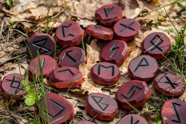 Red runes carved from wood on the ground clipart