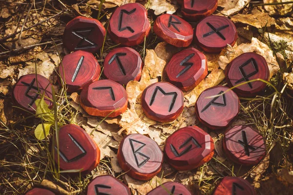 Red runes carved from wood on the ground