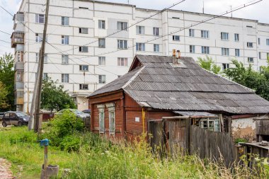 Maloyaroslavets, Rusya - Haziran 2019: Maloyaroslavets'te yüksek katlı bir binanın arka planında eski köy evi (Malojaroslavec, Maloyaroslavec). Karma kent mimarisi