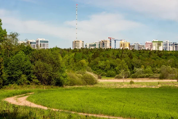 View of the modern urban development from a distance from the forest and fields. Obninsk, Russia - May 2019