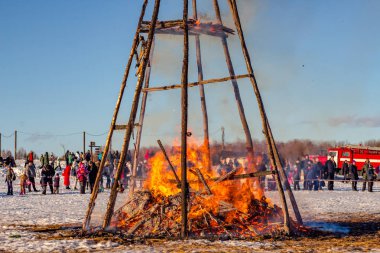 Etnomir, Russia - March 2019: Burning effigy Maslenitsa at sunset, Russian spring holiday Maslenitsa (Maslenica)