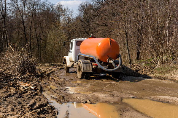 Suction truck driving on a terrible dirty road