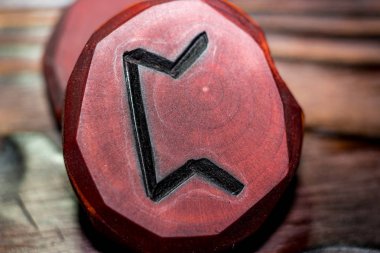 Ahşap zemin üzerine ahşap oyulmuş Rune Pertho (Peord) kırmızı renk - Yaşlı Futhark