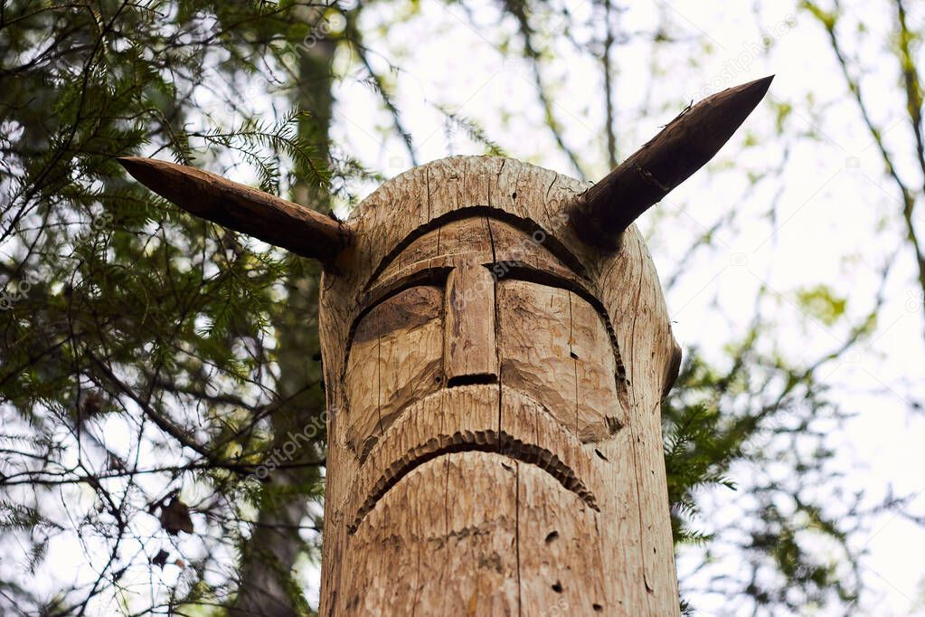 Image of the Slavic deity Veles carved from a tree trunk on a neo-Pagan temple in the forest. Kaluzhskiy region, Russia. Veles - the god of cattle breeding, wealth and wisdom