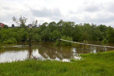 Yağmurdan sonra sel sırasında nehir boyunca taşra asma köprüsü