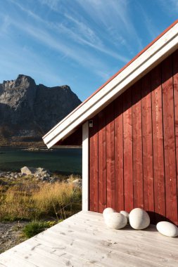 Ahşap Norveç plaj kulübe taşlarla kırpılmış bakış Tromso fiyort, Arctic Circle, Norveç ve dağ tepe bir güneşli mavi gökyüzü gün bakan kıyı üzerinde kapatın