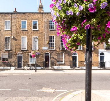 Ön cepheler ve tarihsel tuğla uzun boylu windows ve demir kapının önünde bir bisiklet kaldırım ve elektrik direği ile korkuluk ile Londra Teras Evler, kemerli kapılar