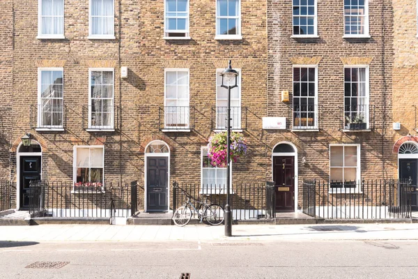 フロント正面や背の高い窓と鉄手すりを前面歩道と街灯に自転車でロンドンのテラス住宅歴史的なれんが造りのアーチ型ドア — ストック写真