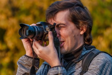 Erkek fotoğrafçı dijital kamerada çekim yapıyor.