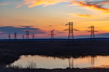 Yüksek gerilim silüeti gün batımında nakleder. Norilsk. 22 Eylül 2018