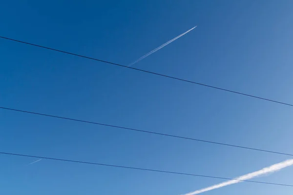 Arkalarında beyaz contrails ile mavi gökyüzünde uçaklar e çapraz