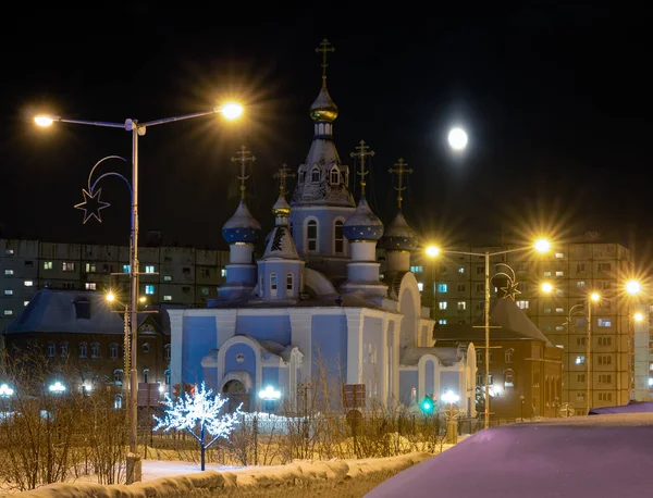 Ay ve kilise ile kış gecesi ışıklar. Norilsk