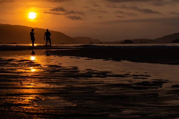 Silhouettes of people on the background of a golden dawn on the