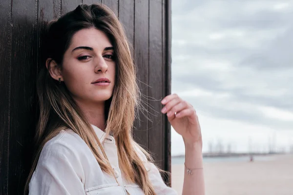 Une jeune hipster belle femme aux longs cheveux bruns en été avec un jean denim au fond marron — Photo