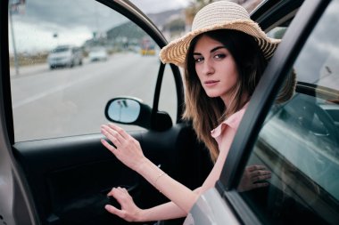 arabasının kapısını açan bir şapka ile güzel bir kadın