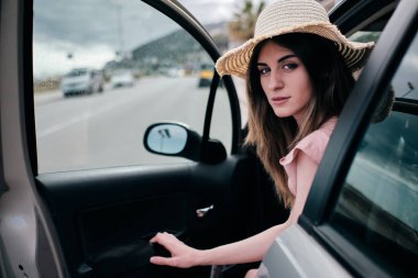arabasının kapısını açan bir şapka ile güzel bir kadın