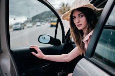 arabasının kapısını açan bir şapka ile güzel bir kadın