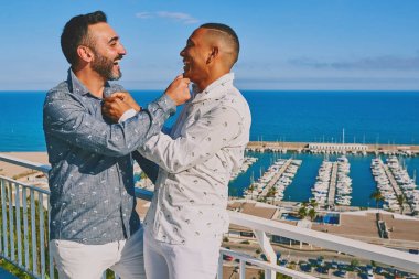 arkalarında deniz ile güneşli bir yaz gününde bir gay çift