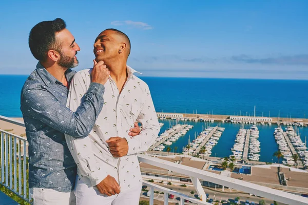 Una pareja gay en un soleado día de verano con el mar detrás de ellos — Foto de Stock
