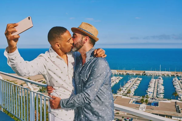 Um gay casal usando um celular — Fotografia de Stock