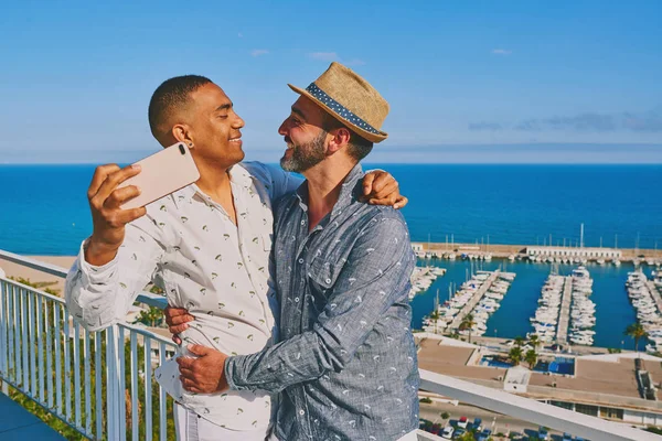 Una pareja gay usando un teléfono móvil — Foto de Stock