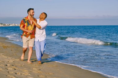 a gay interracial couple at the beach clipart