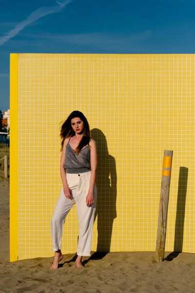 Egy fiatal modell hosszú haja előtt egy sárga fal egy nyári napon — Stock Fotó