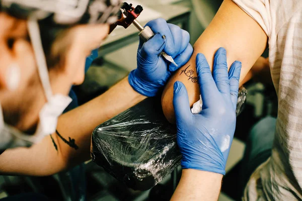 a man tattooing a basket ball to a young lady