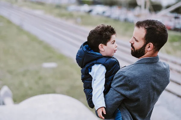 Baba ve oğul arkalarında tren rayları ile