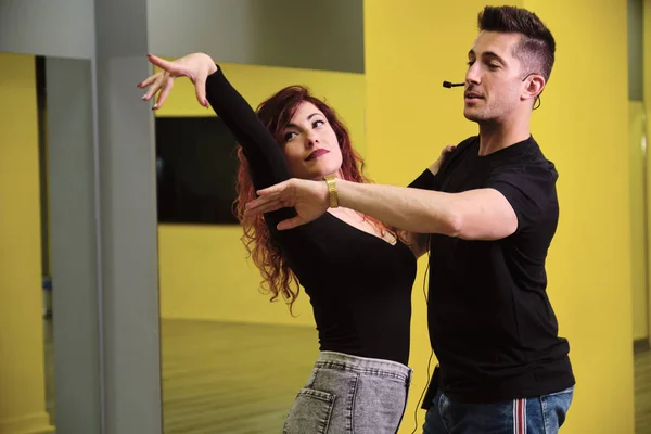 Salsa ve Bachata'ya ders veren genç bir kadın ve bir adam.