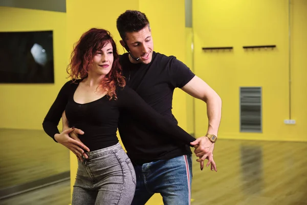 Salsa ve Bachata'ya ders veren genç bir kadın ve bir adam.